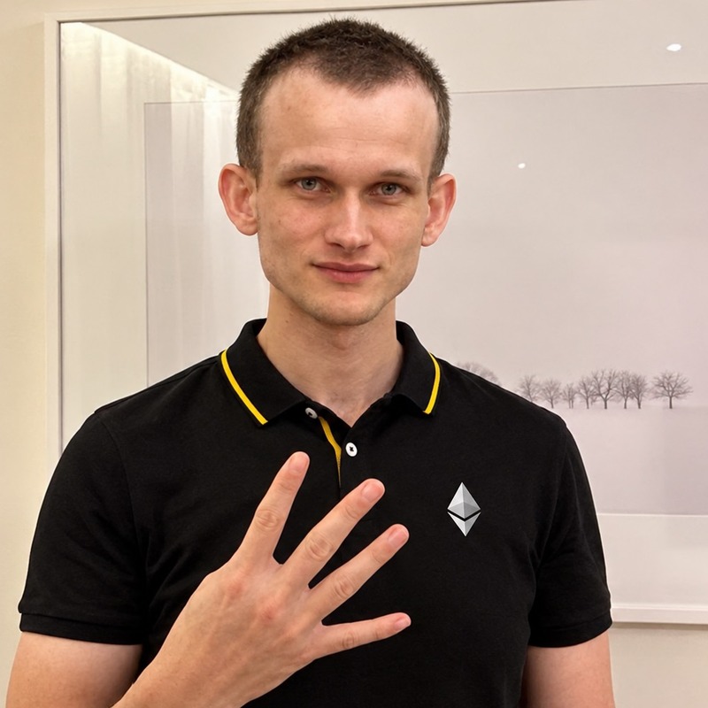 Token logo: a man in a black polo with an Ethereum logo, holding up four fingers